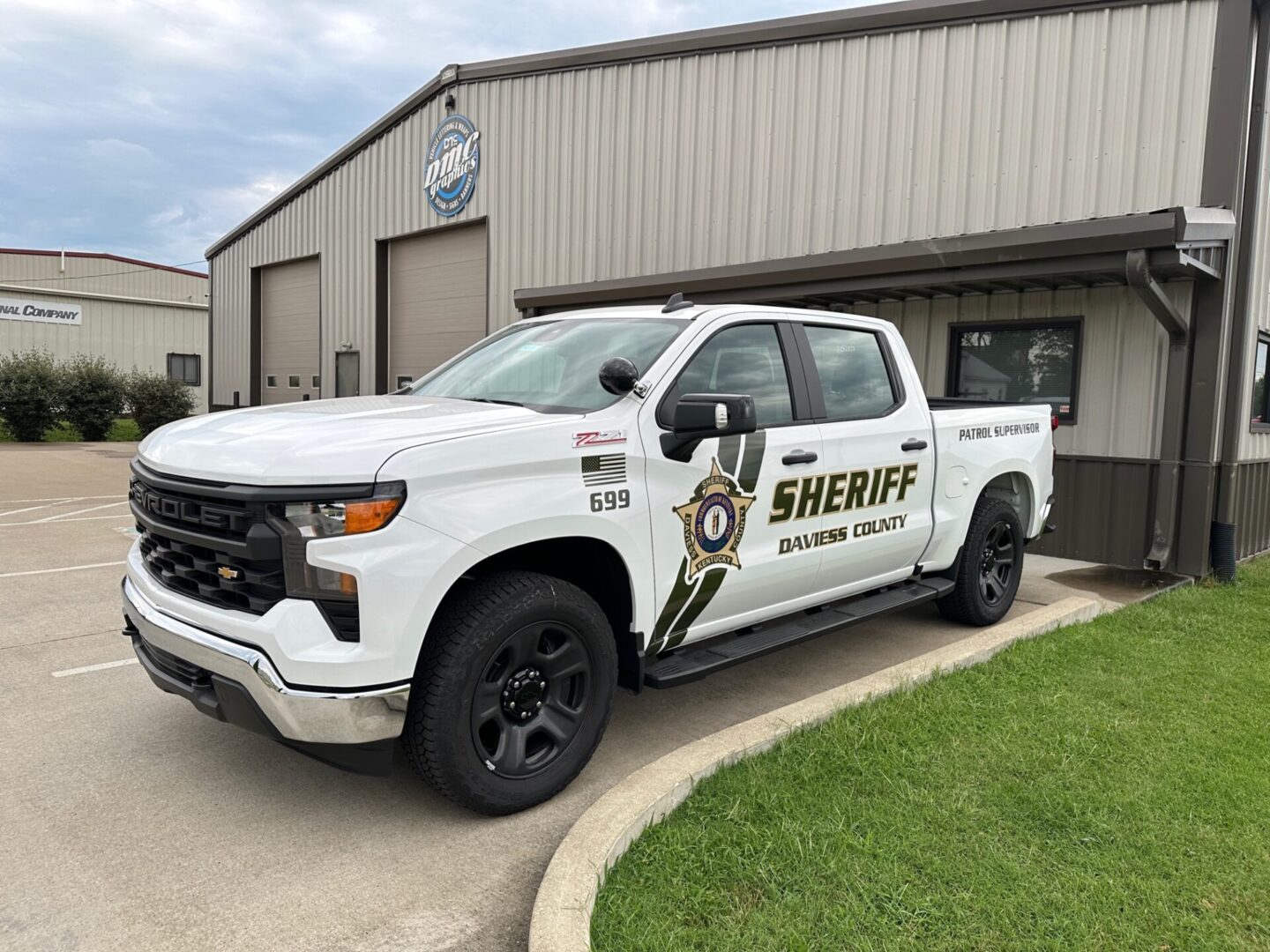 A white truck parked in front of a building.