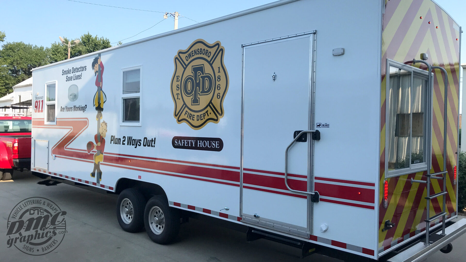 A white trailer with a fire department logo on it.