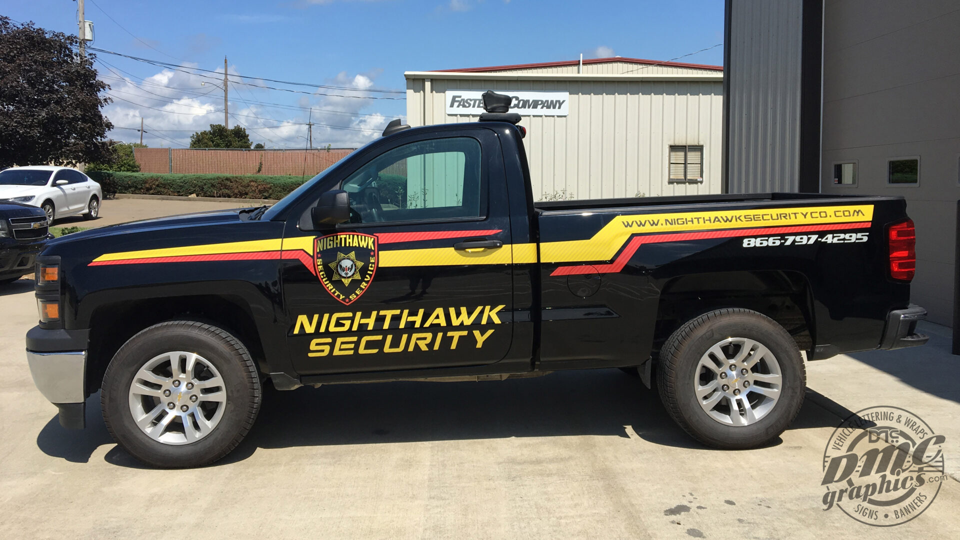 A black truck with yellow and red stripes on it.