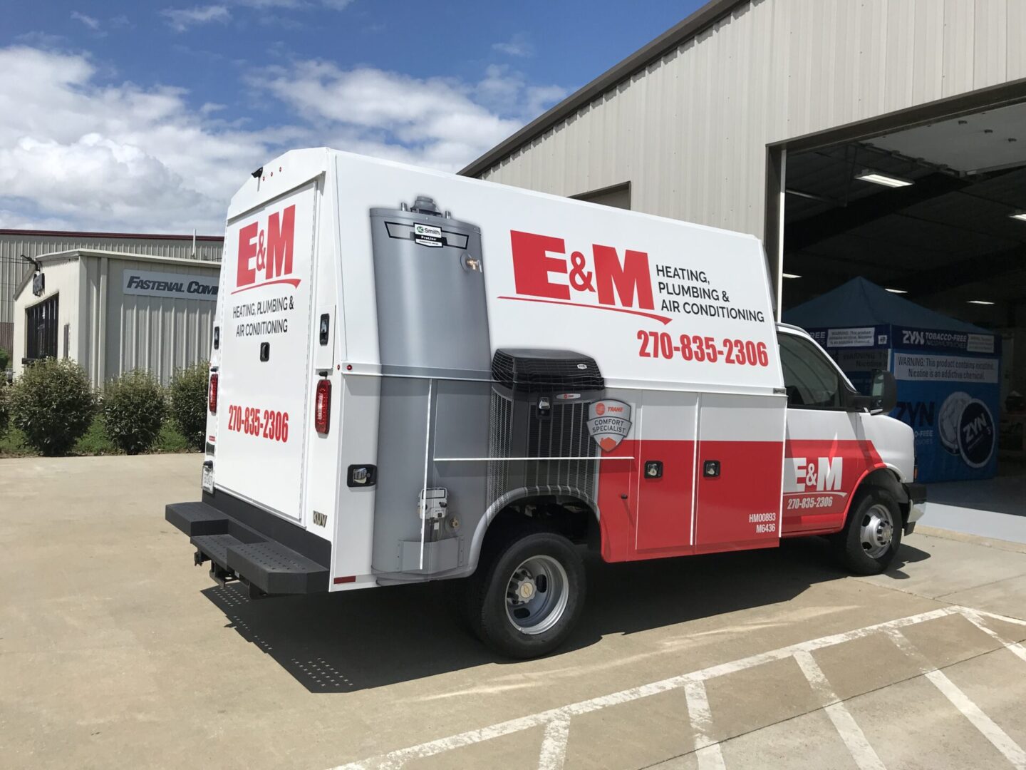 A van parked in front of a building with the door open.