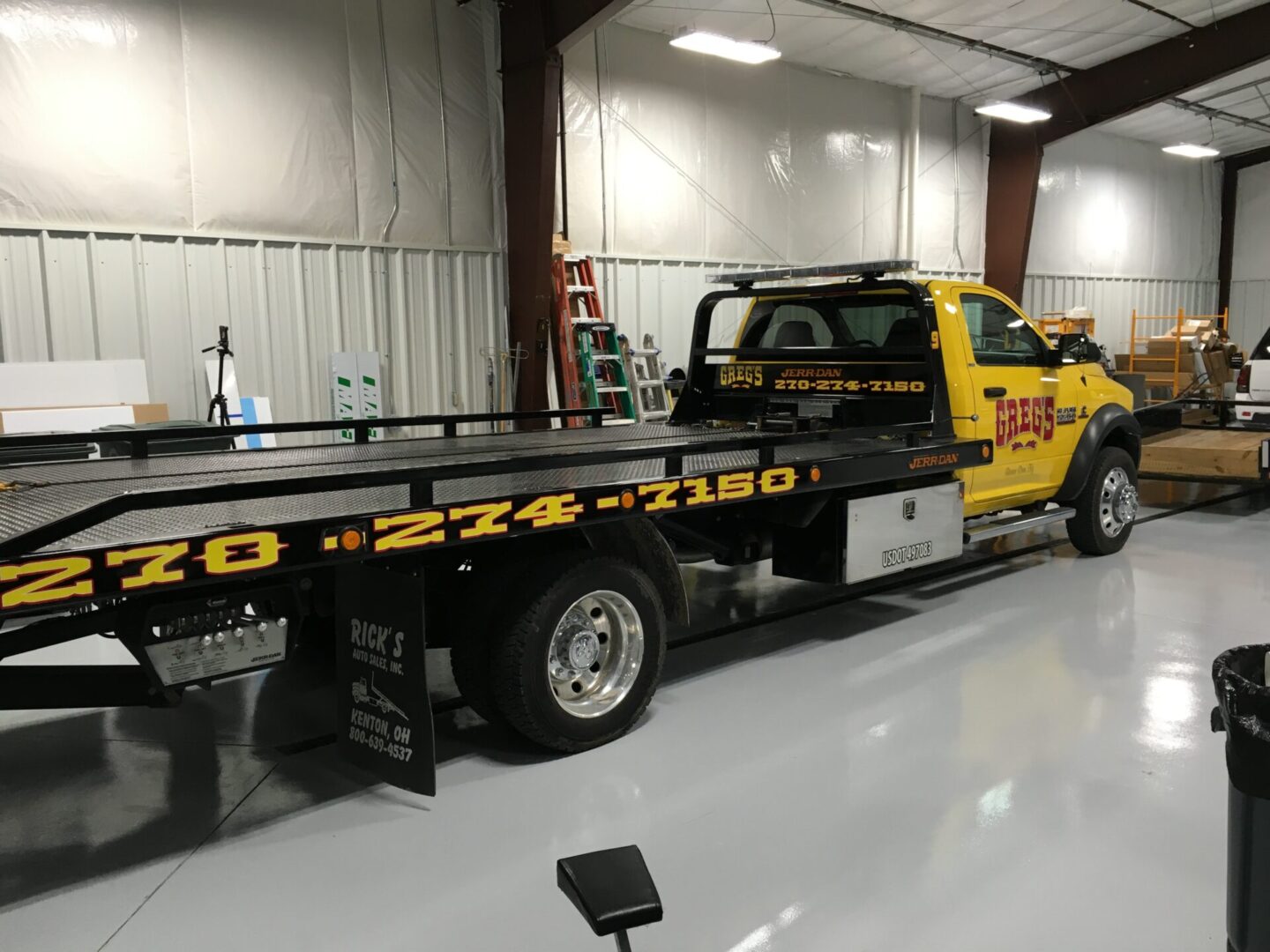 A yellow tow truck parked in a garage.