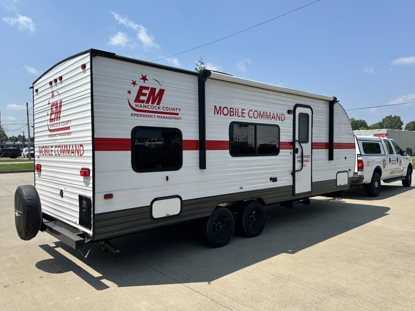 A white and red trailer parked in a parking lot.