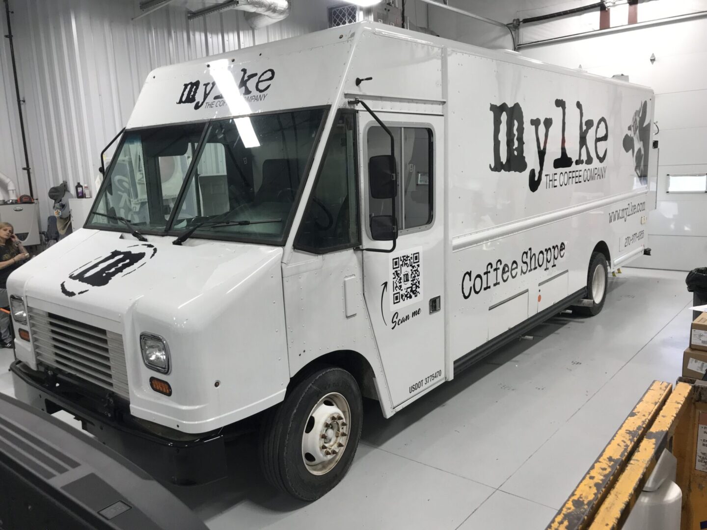 A white food truck parked in a room.