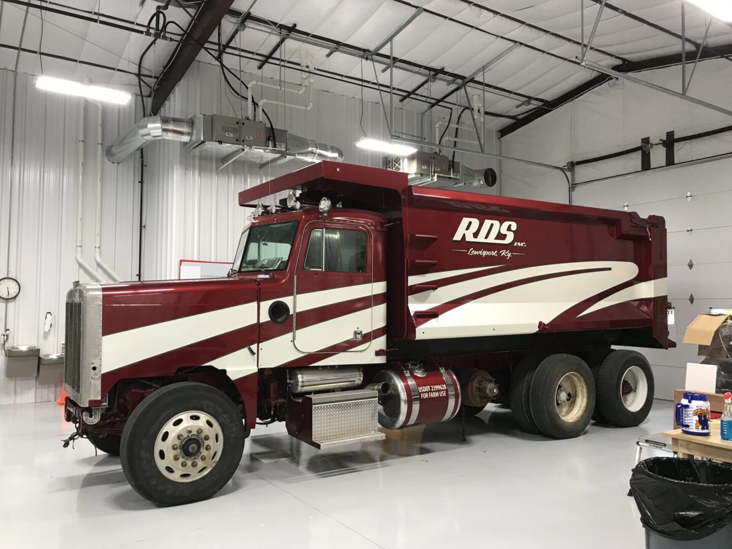 A red and white truck parked in a garage.