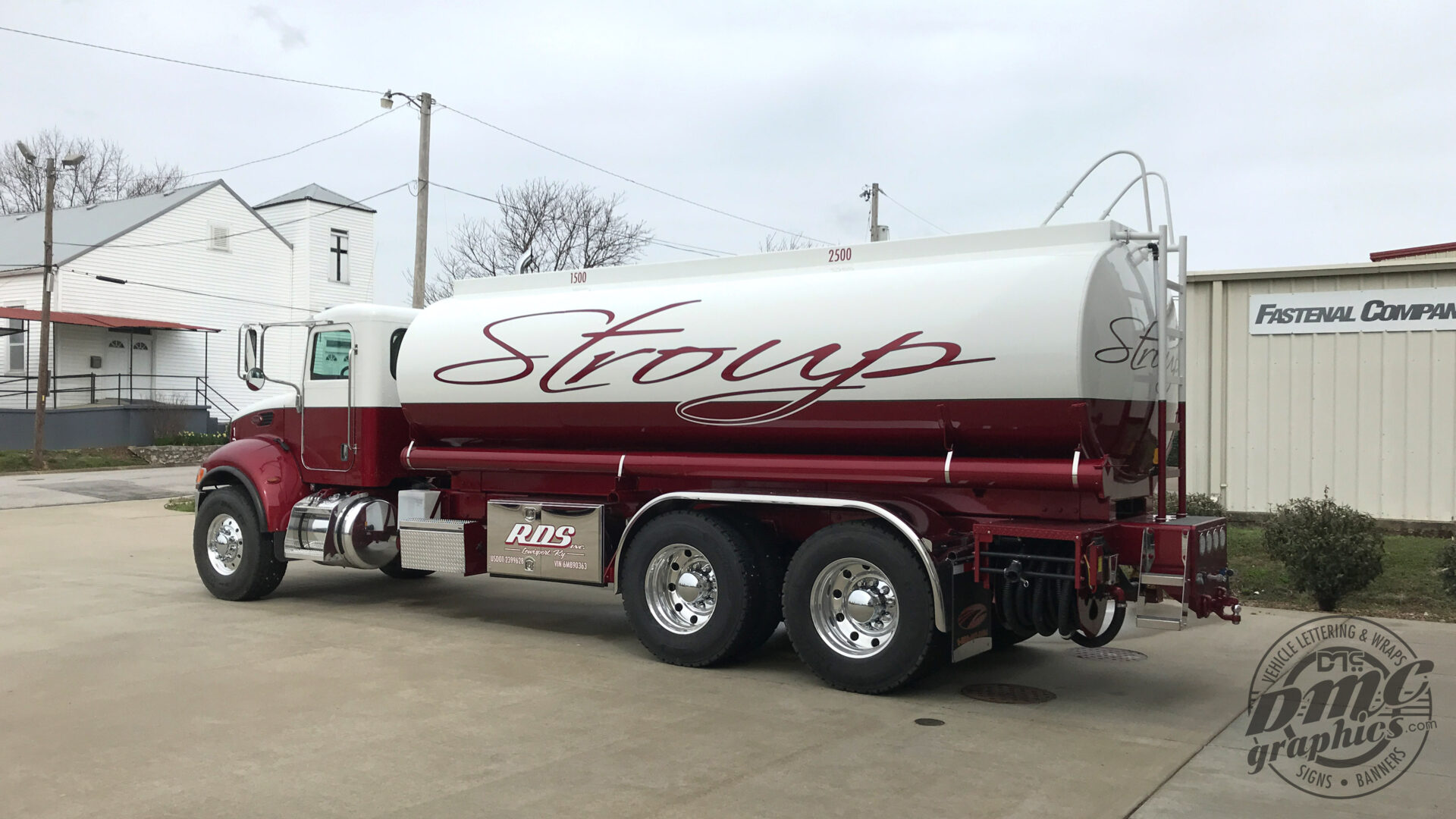 A large white and red truck parked in the lot.