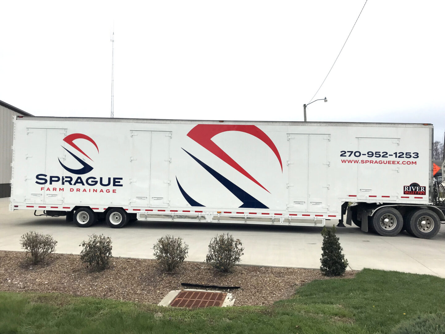 A large white truck driving down the street.