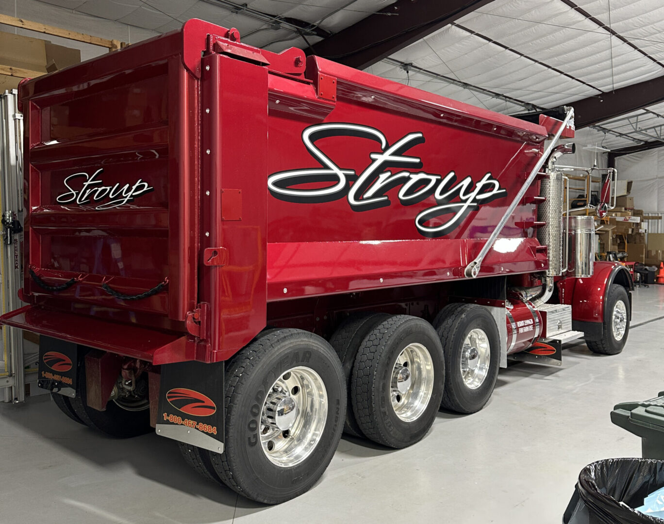 A red dump truck parked in a garage.