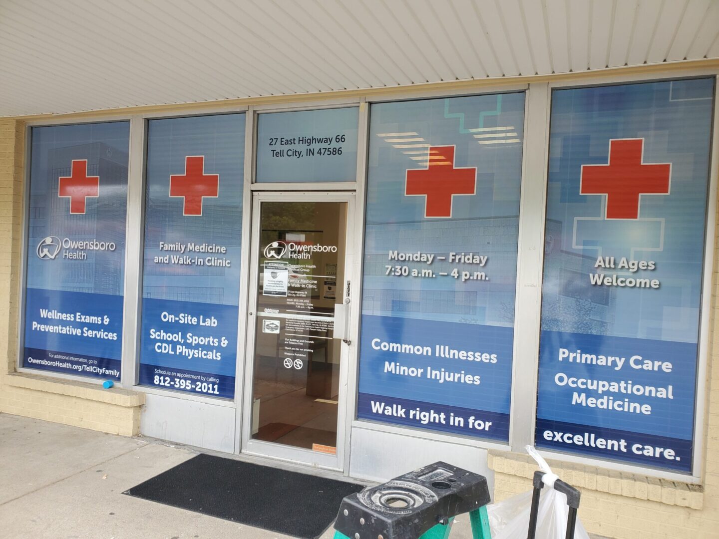 A medical office with red cross signs on the front of it.