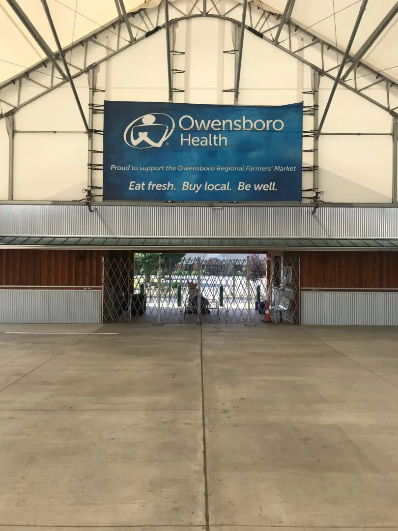 A large sign hanging from the side of an airport.