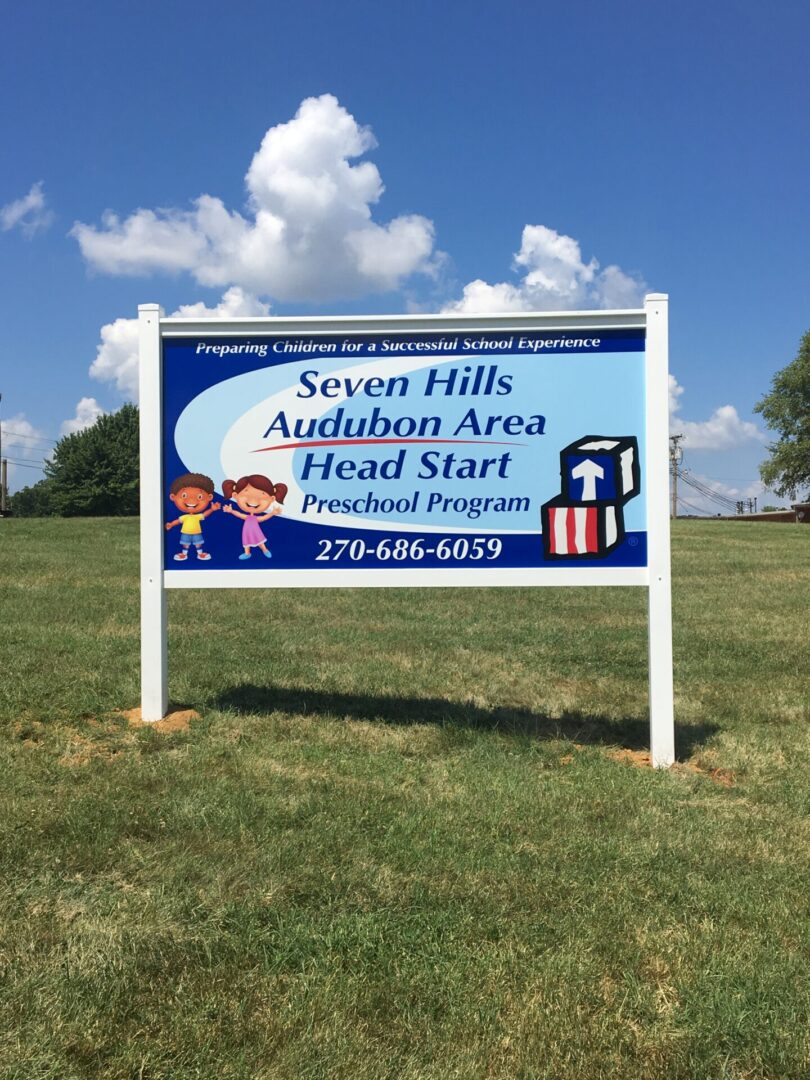 A sign in the grass with a sky background