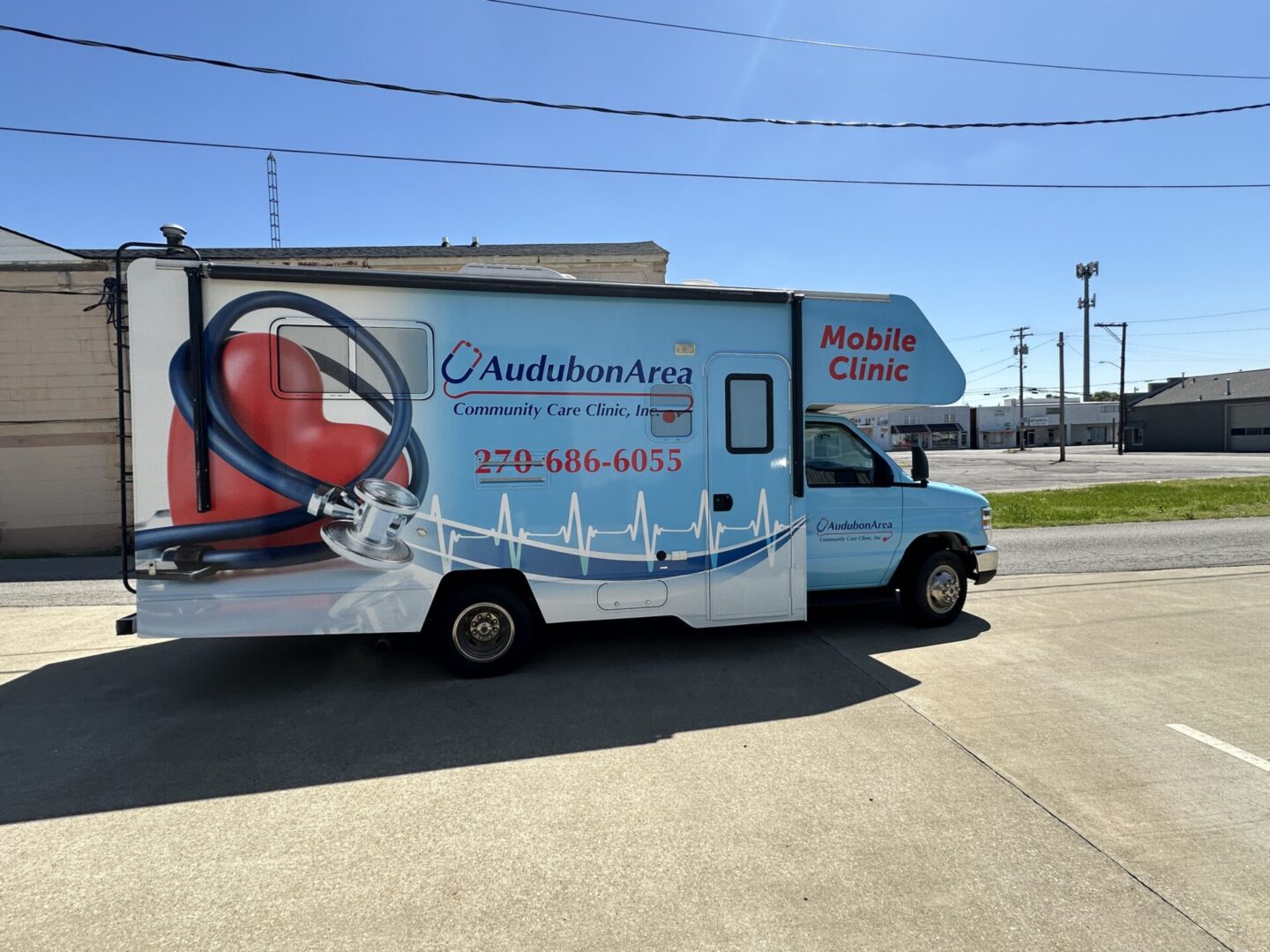 A blue truck with a white and red advertisement on it.