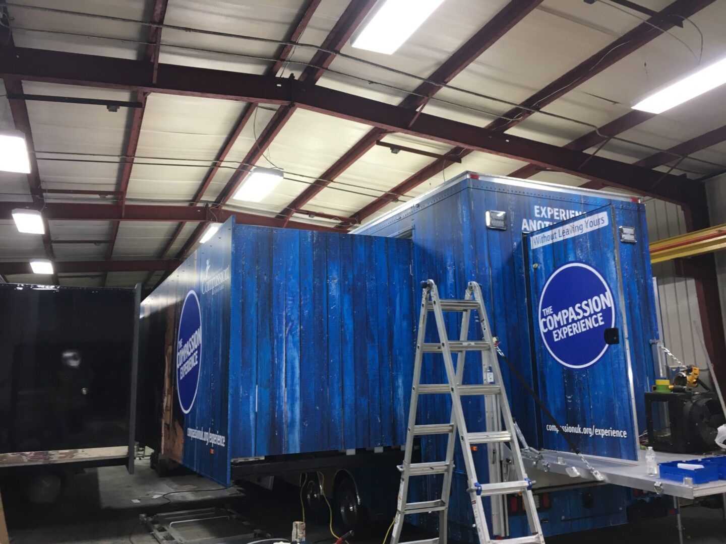 A ladder is in front of a trailer.