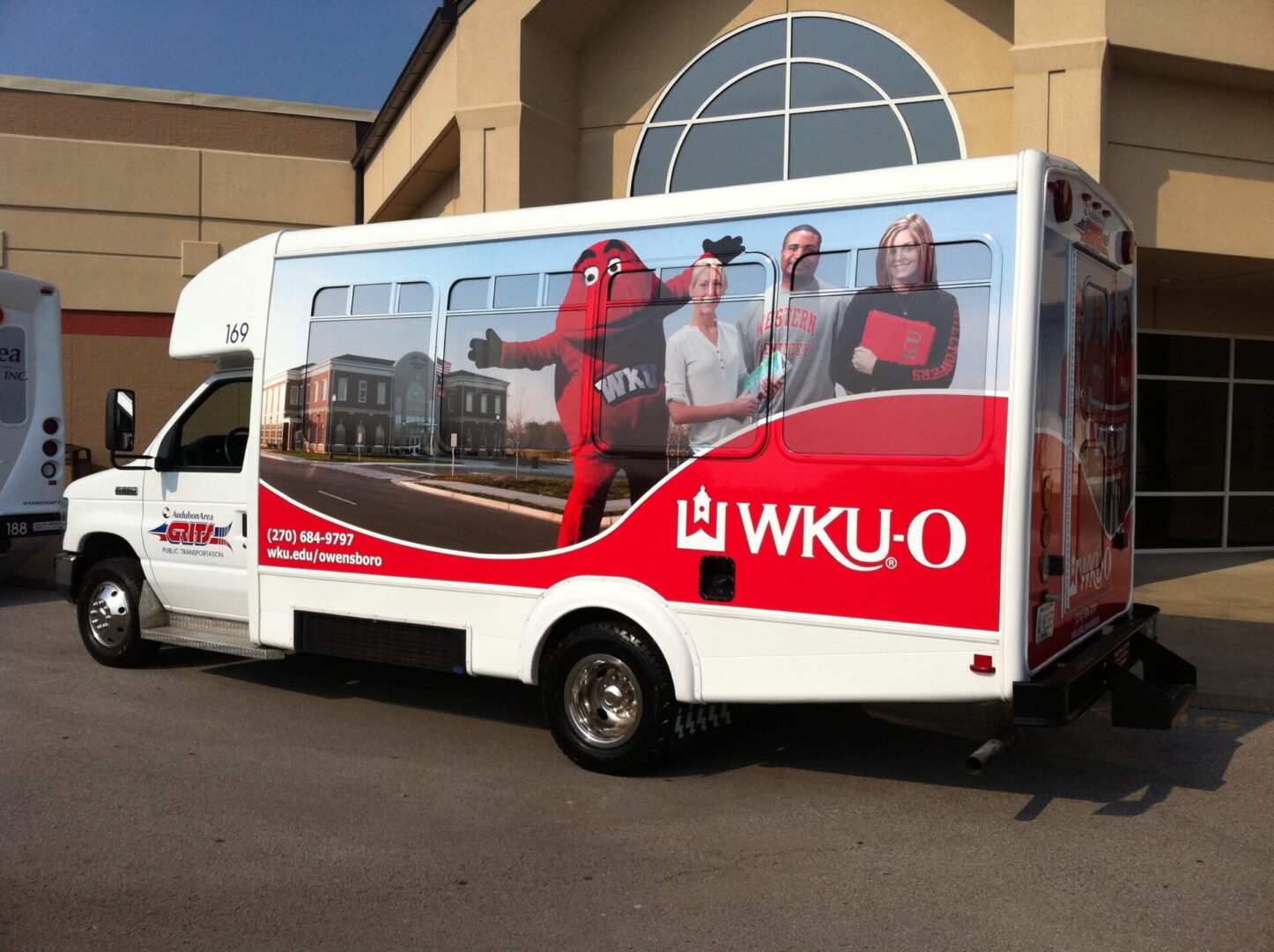 A wku-o bus parked in front of a building.