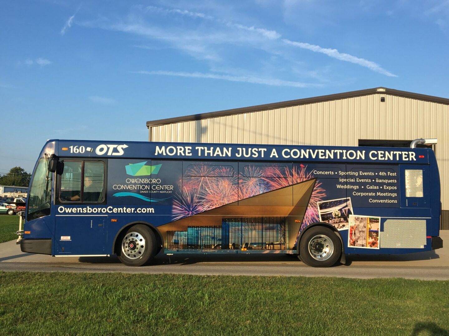 A bus parked in front of a building with advertising on it.