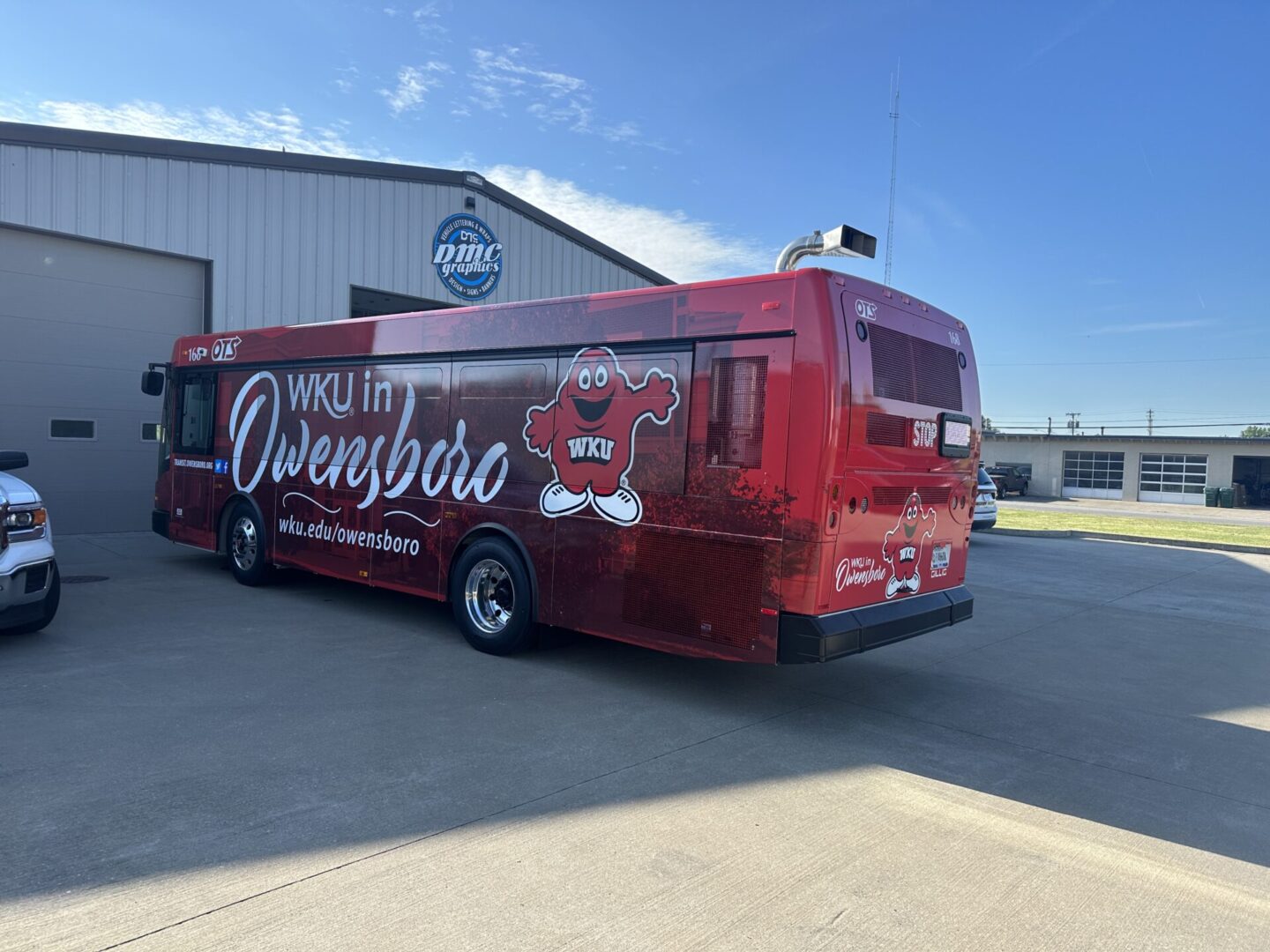 A red bus parked in front of a building.