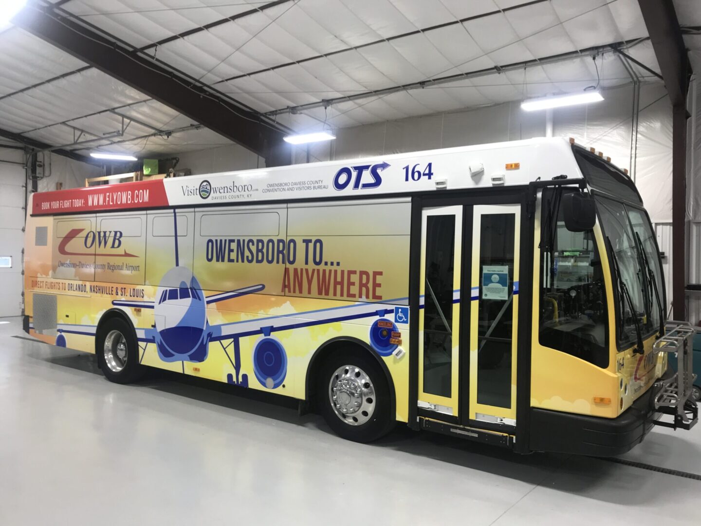 A yellow bus with blue and white lettering.