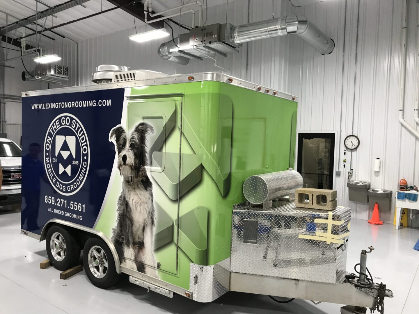 A green and white trailer with a dog on it