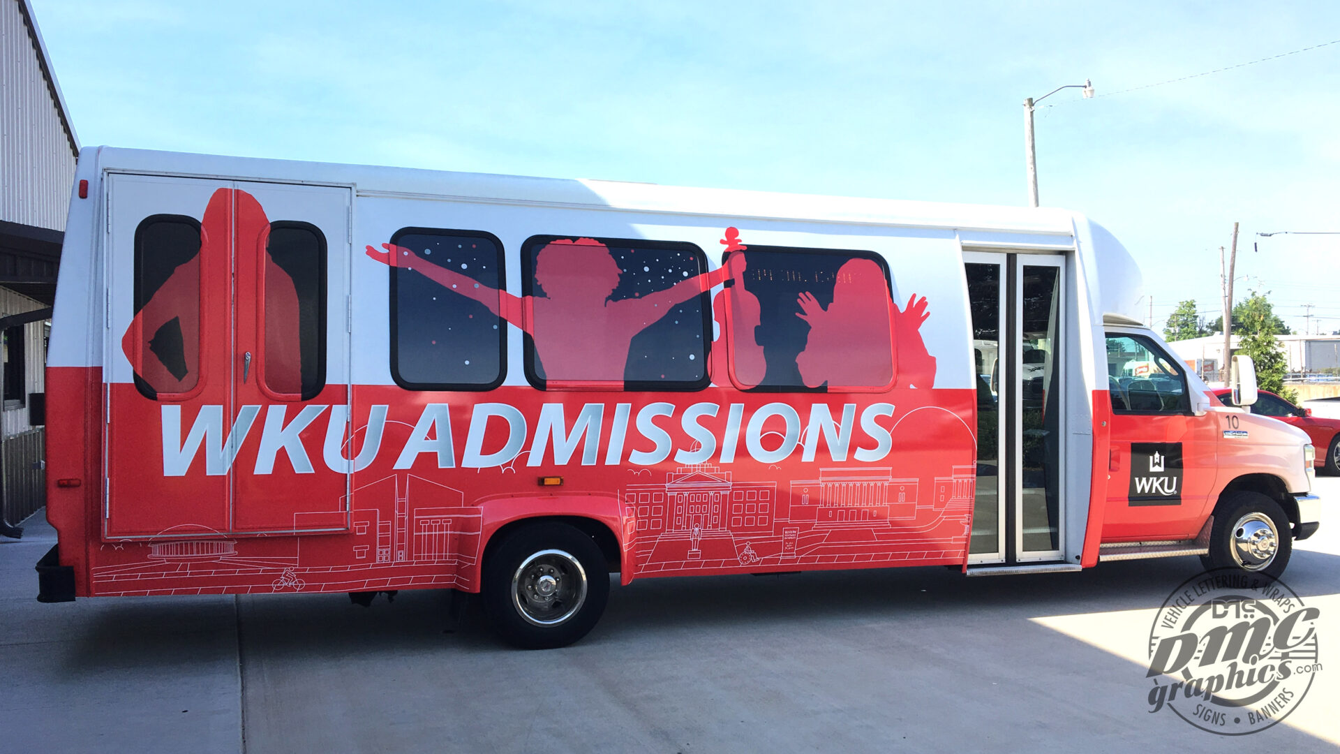 A red and white bus with the word ku admissions on it.