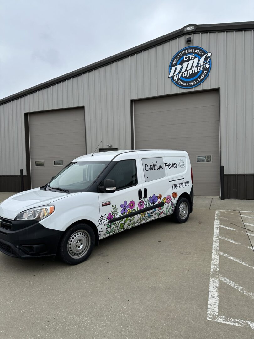 A white van parked in front of a building.