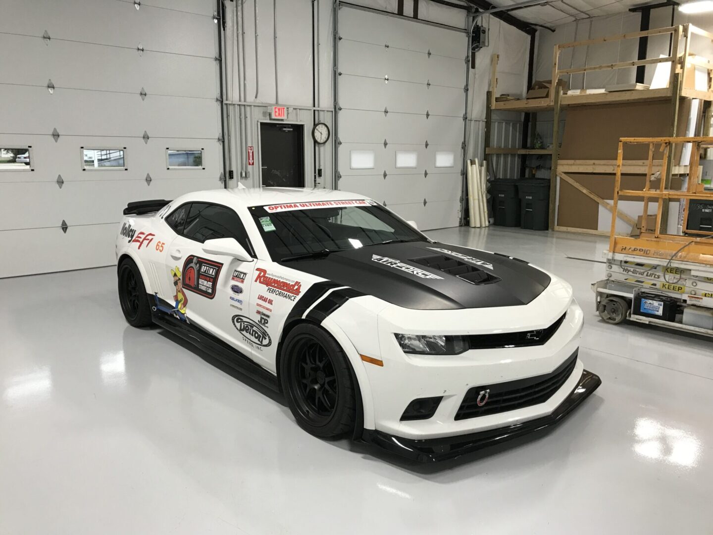 A white car with black stripes on the hood.