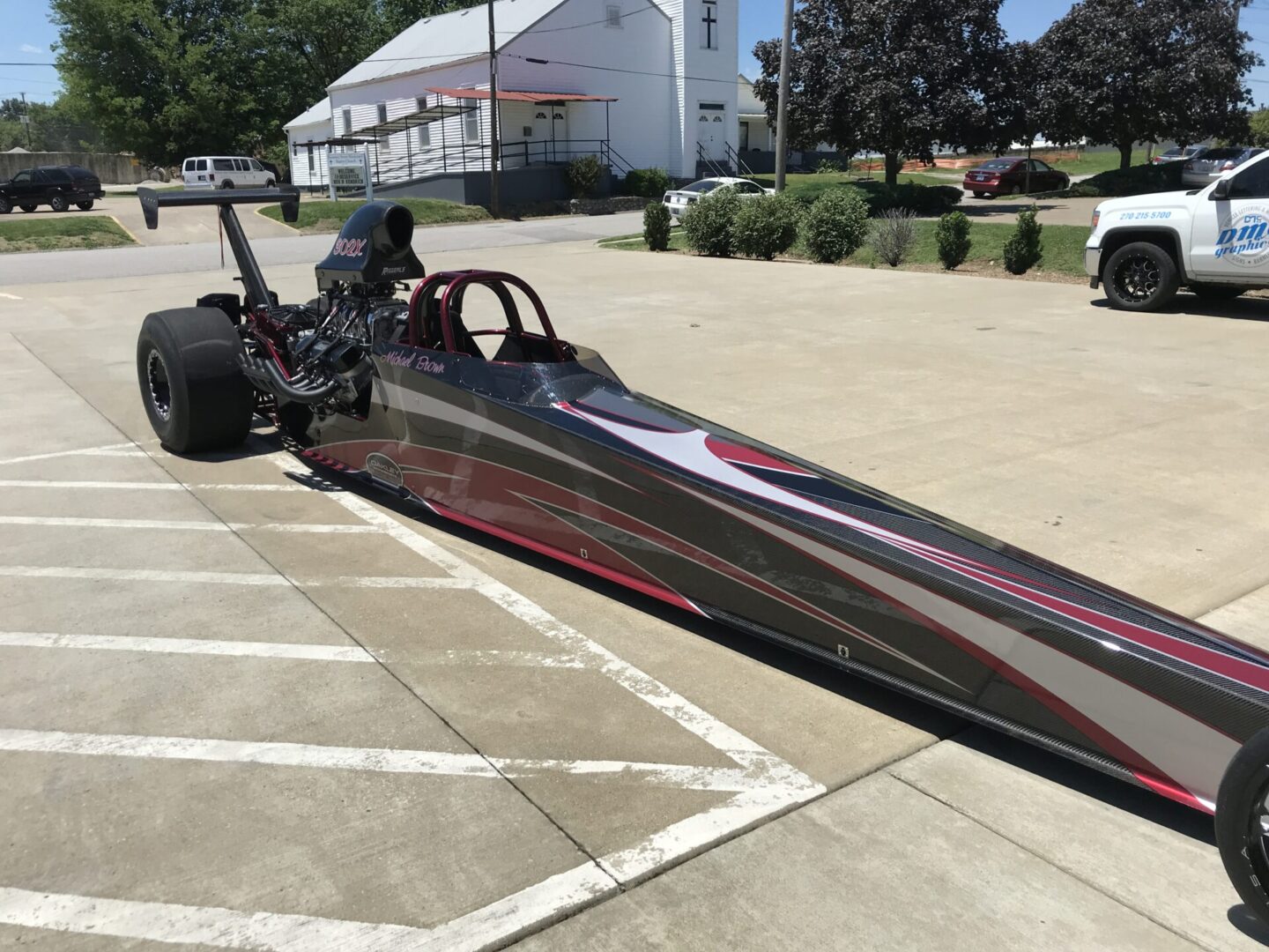 A dragster sitting on the side of a road.