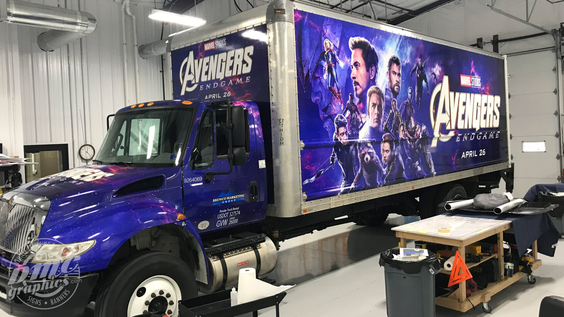 A large truck with avengers on it's side.