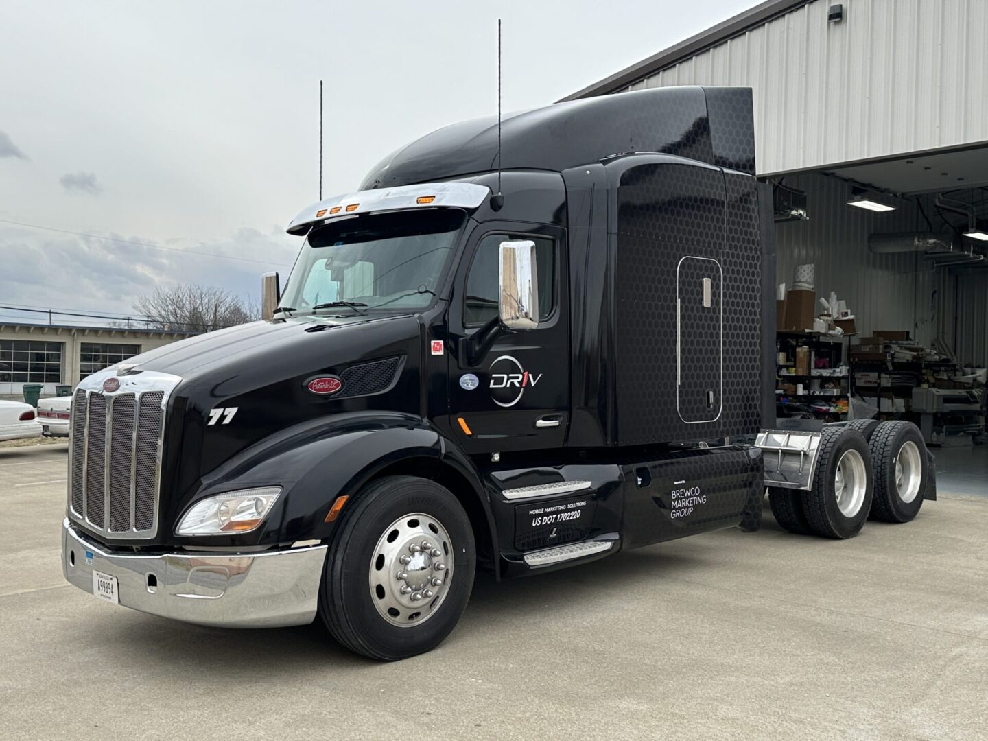 A black semi truck parked in front of a building.