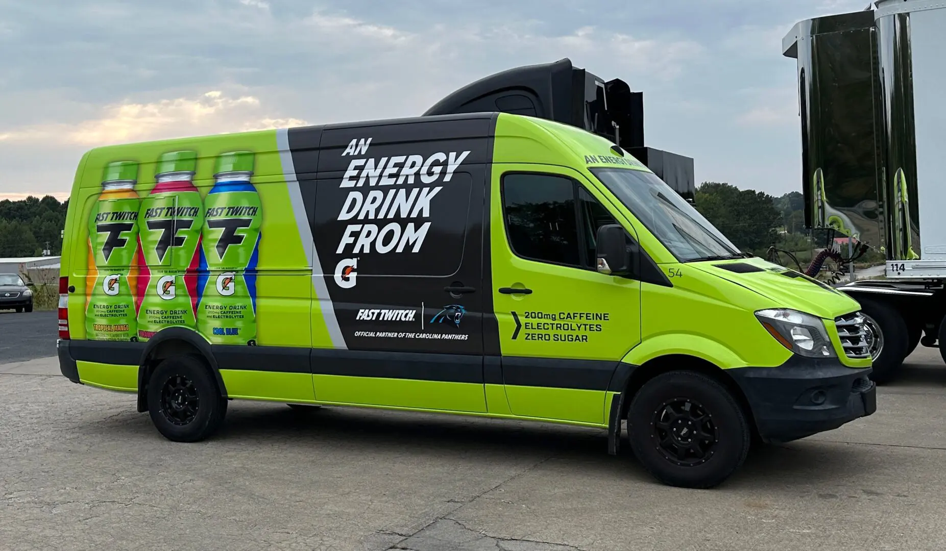 A green and black van with an advertisement on the side.