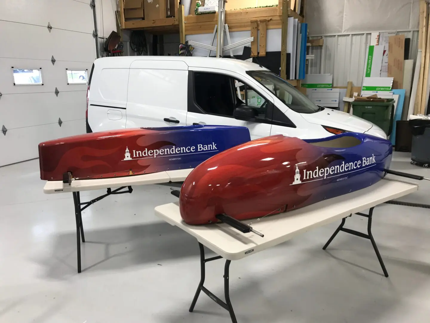 Two red and blue vehicles are parked in a garage.