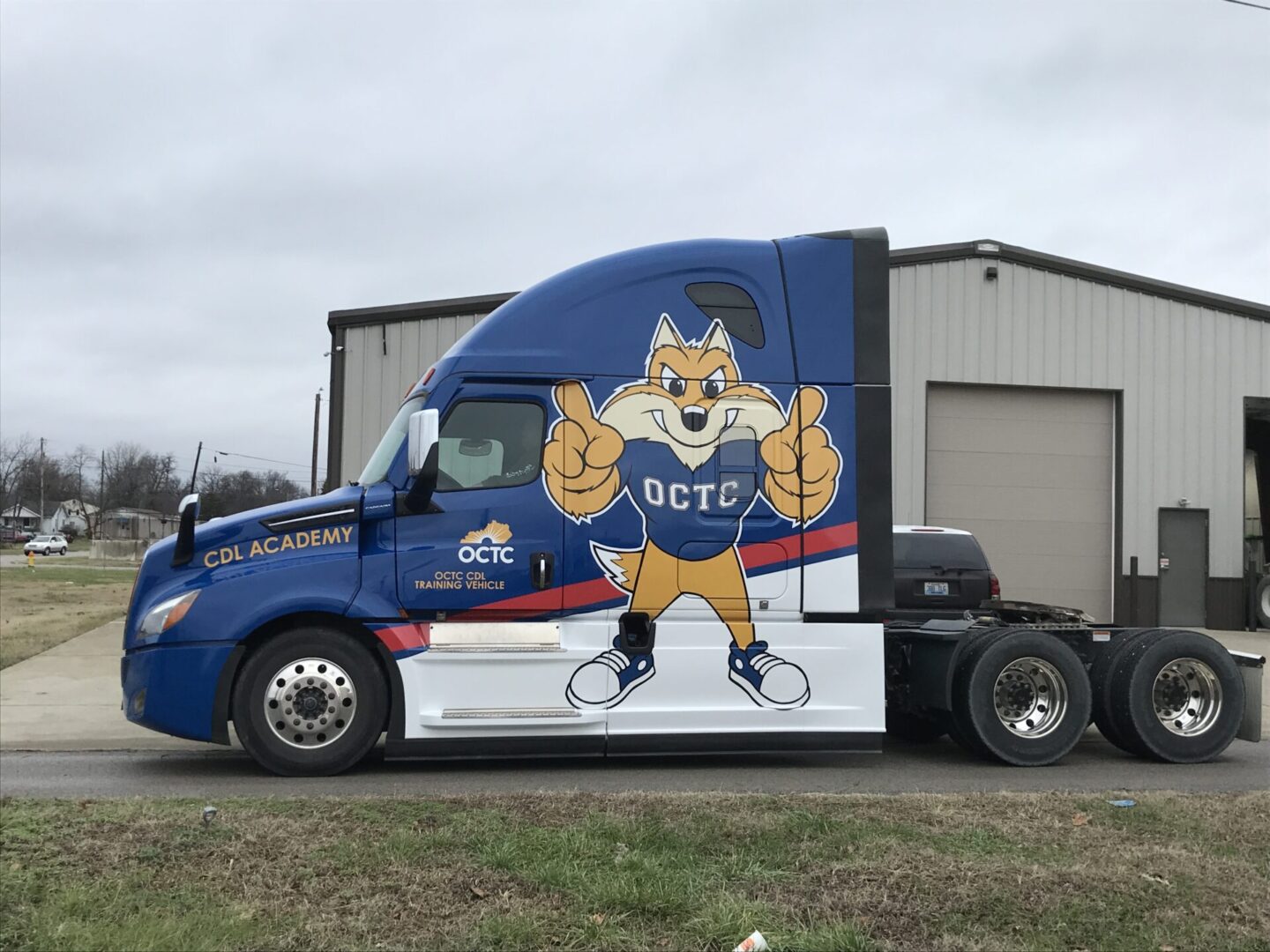 A semi truck with a mascot painted on the side.