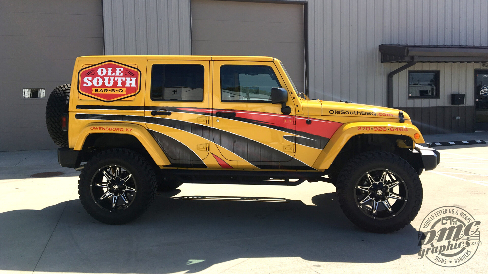 A yellow jeep with a black and red stripe on the side.