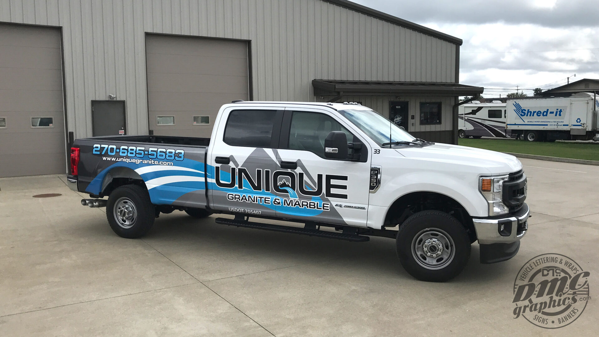 A white truck with blue and black lettering