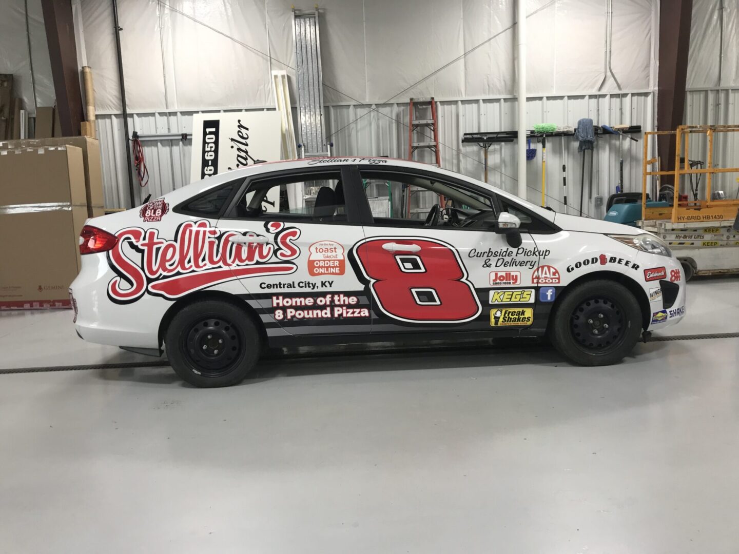 A white car with red and black numbers on the side.