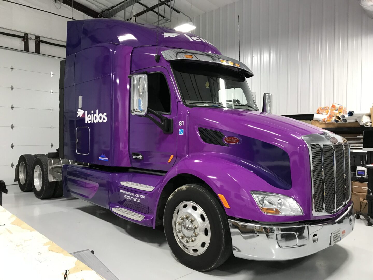 A purple truck parked in a warehouse.