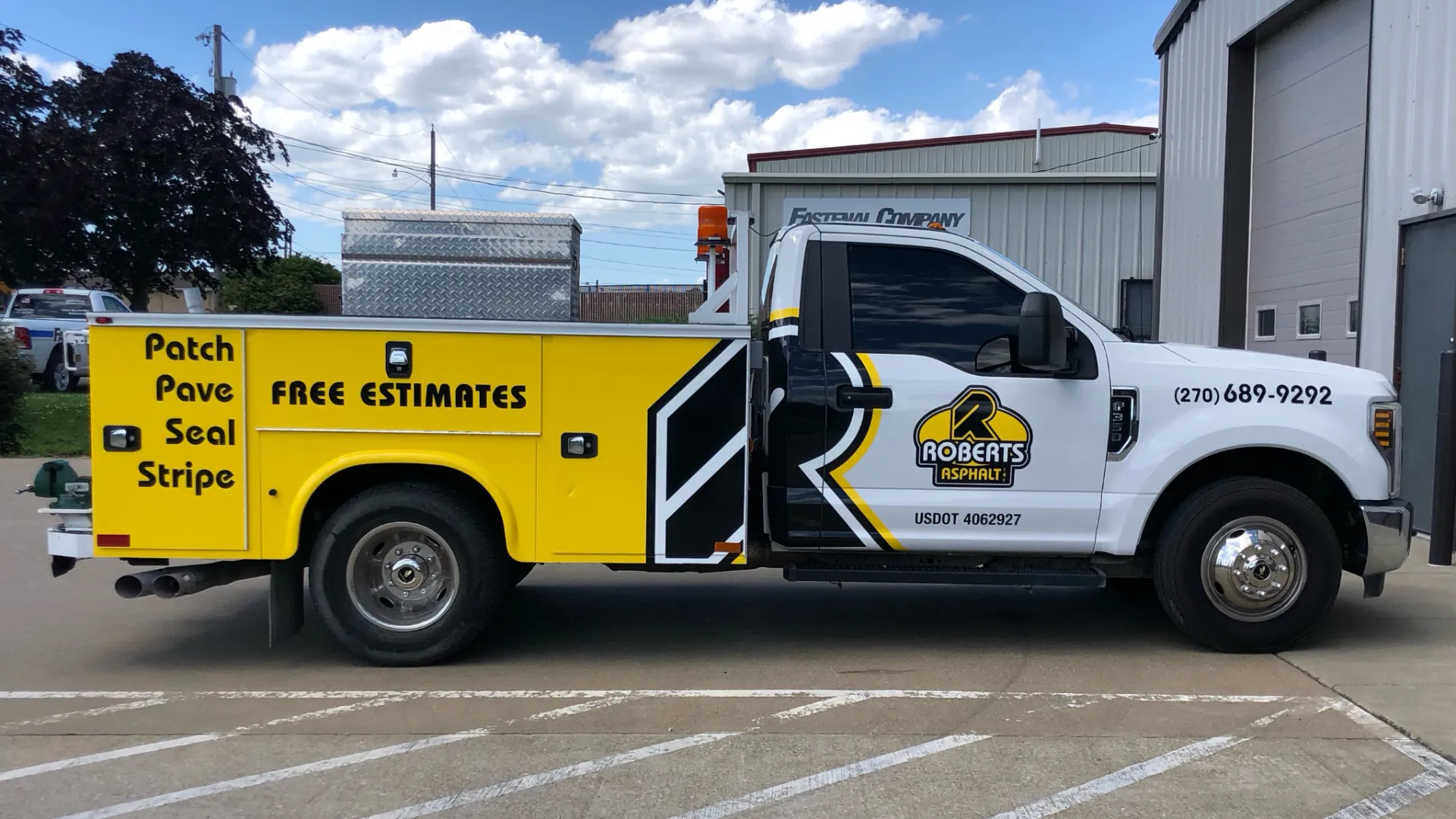 A yellow and white truck parked in a parking lot.