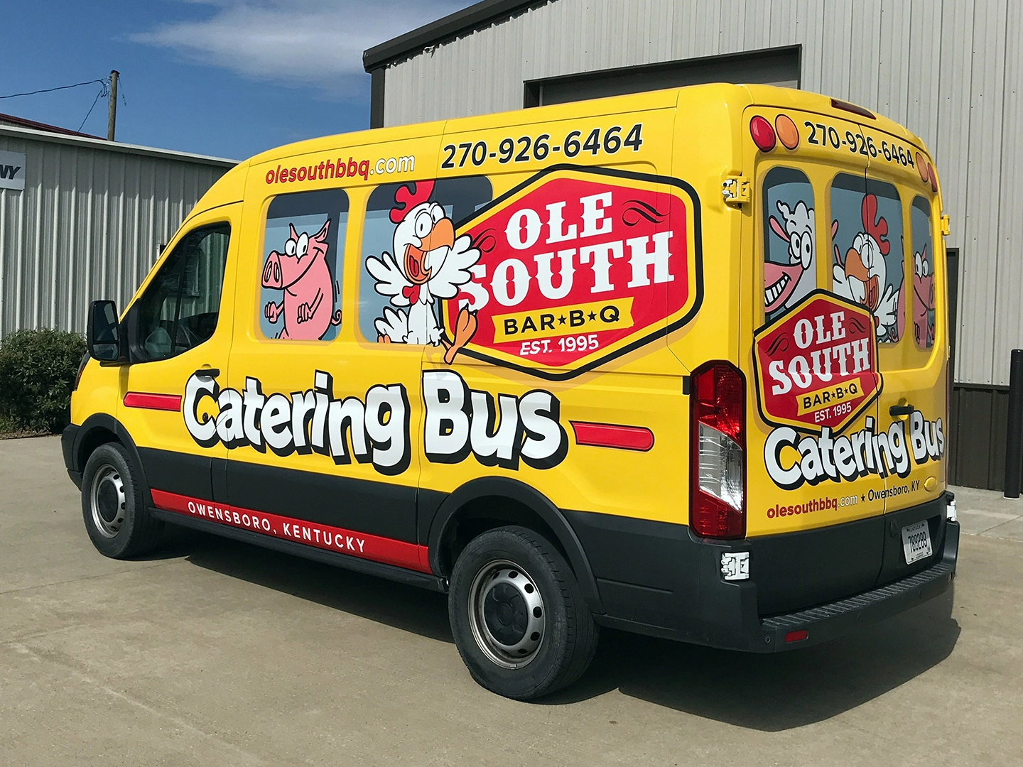 A yellow and red catering van parked in front of a building.